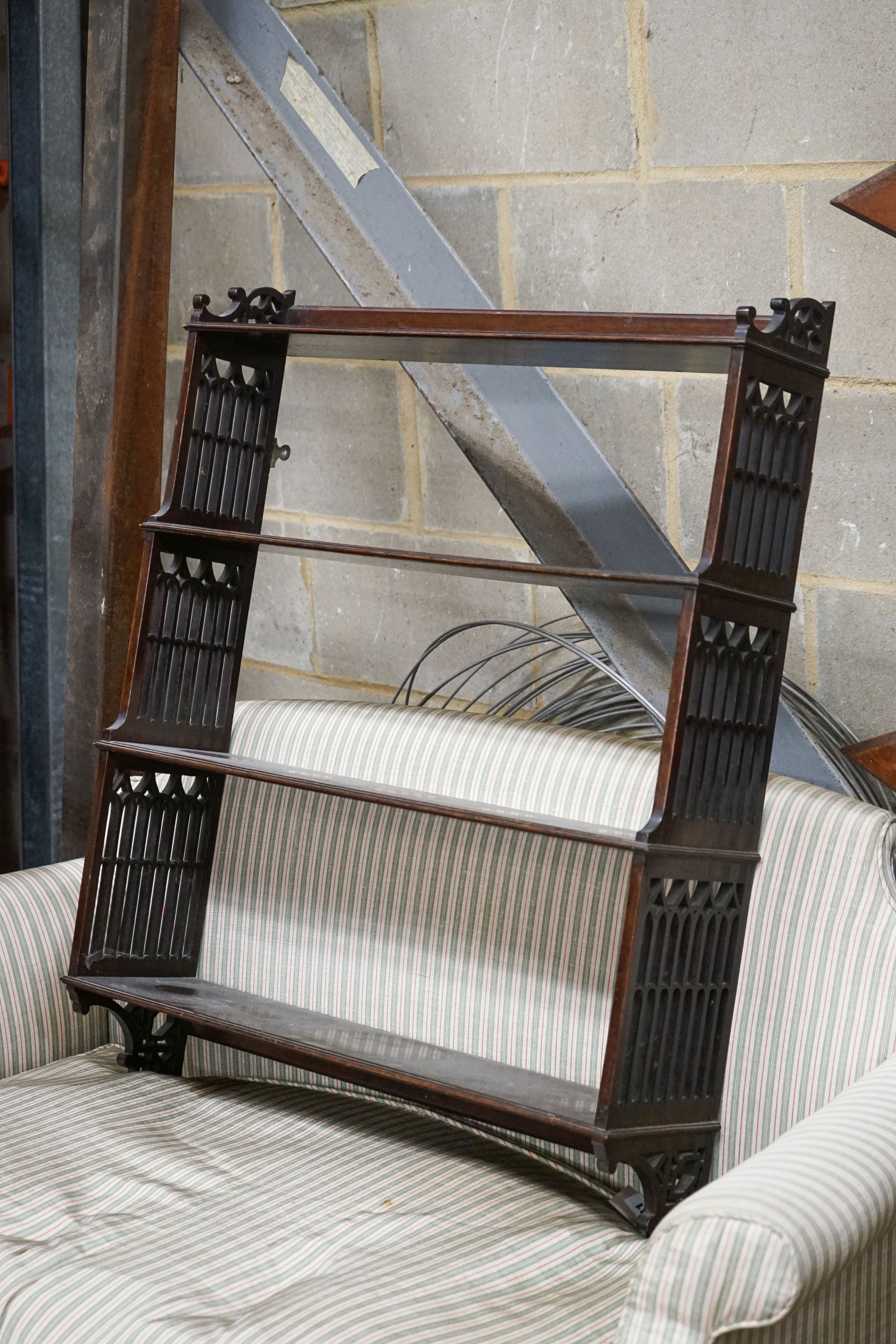 A George III style fret cut mahogany hanging four-tier wall shelf, width 70cm, depth 18cm, height 88cm